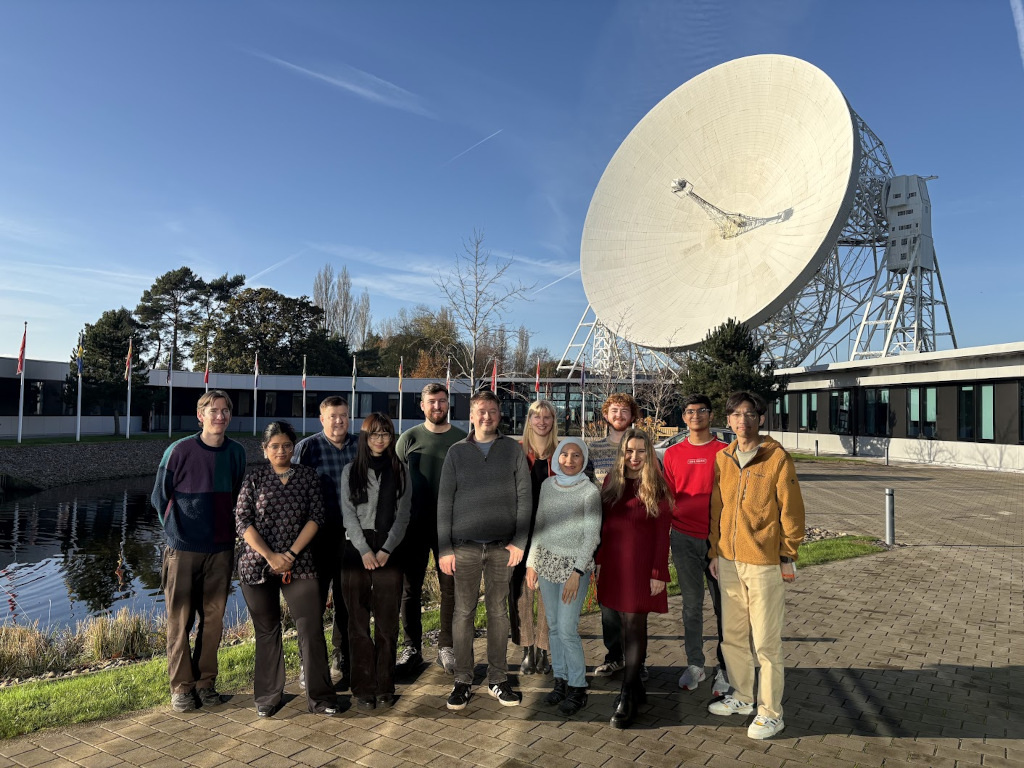 (Left to right:) Jacob, Sohini, Hugh, Isabelle, Tom, me, Katrine, Bella, Jordan, Nastassia, Pranav, and Zheng in front of the Lovell Telescope and SKAO building at Jodrell Bank.